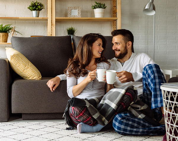 Loving couple relaxing at home with coffee mugs